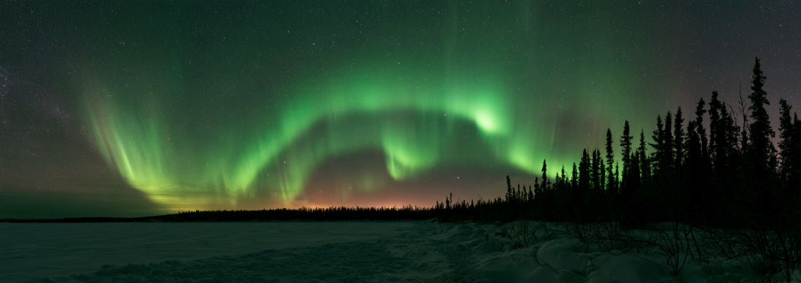 Emerald green aurora borealis curtains dancing in clear subarctic sky