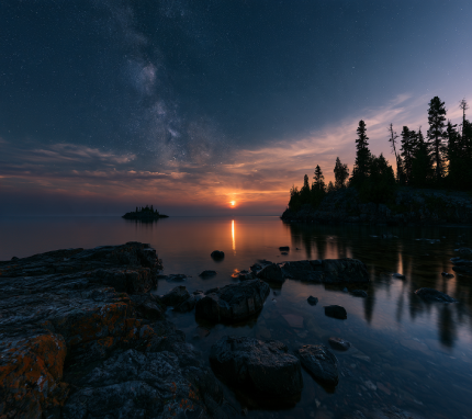 Star-filled night sky over ancient granite shoreline of Lake Superior
