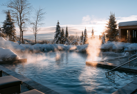 Outdoor steaming thermal bath surrounded by snow