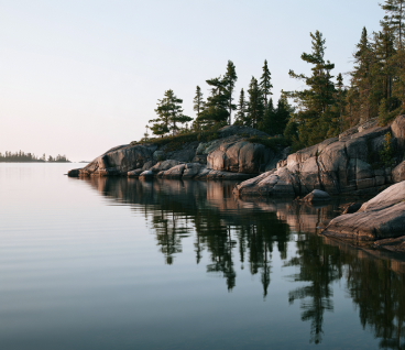 Tranquil granite shoreline and pine waters in Ontario lake country